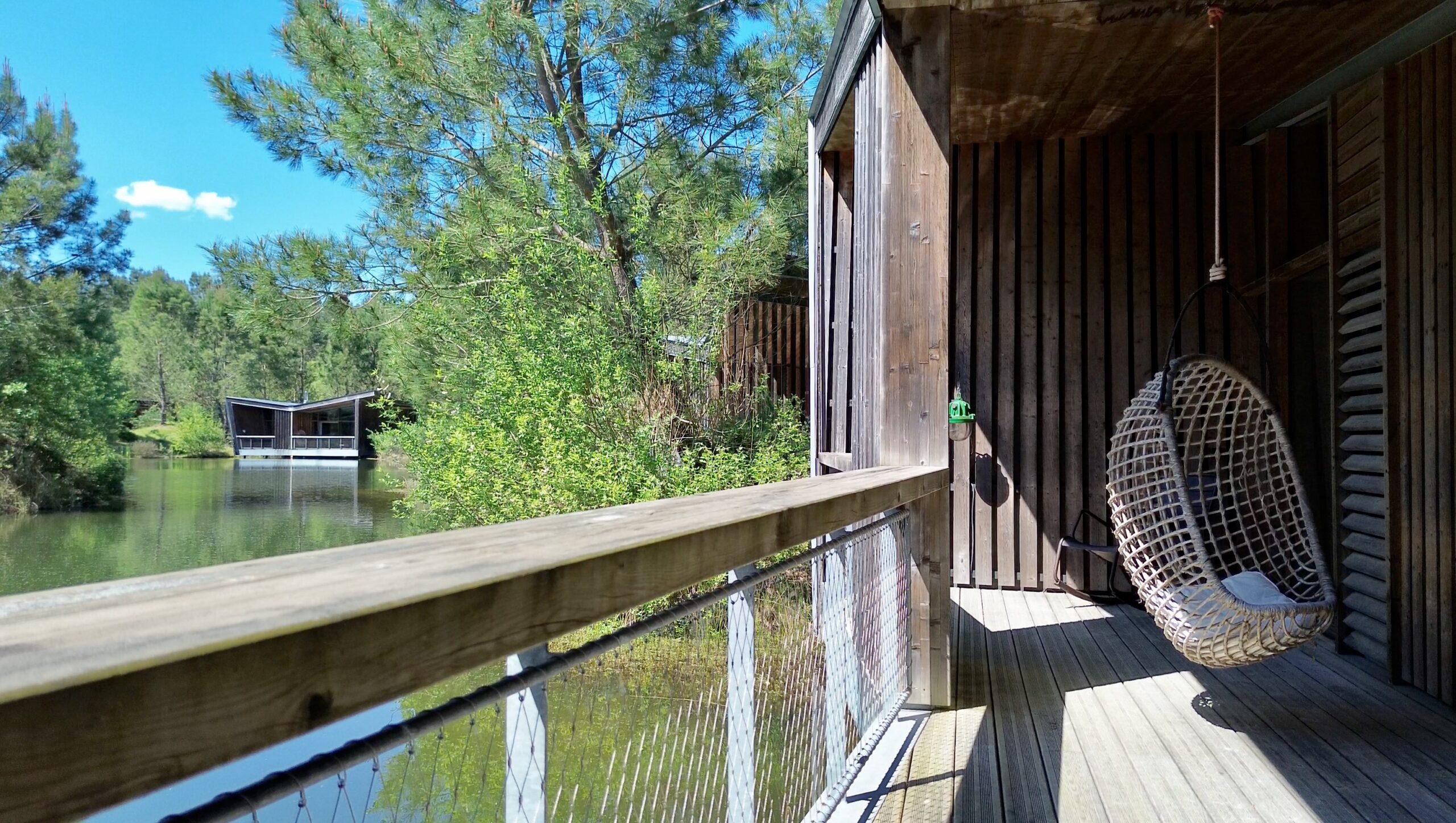 Terrasse en bois et vue lodge sur l'étang